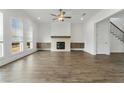 Spacious living room is enhanced by a fireplace, many windows and wood look flooring, perfect for gatherings at 11335 Bennett Ln, Johns Creek, GA 30097