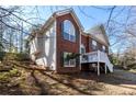 A two-story brick home featuring a deck with white railings, large windows, and lush landscaping at 1012 Crown River Pkwy, Mcdonough, GA 30252