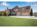 Home's rear elevation, showcasing a three-car garage and yard at 511 Baxter Way, Marietta, GA 30064