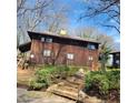 Two-story house featuring a stained wood exterior and a sloped, landscaped yard at 7 Quail Run, Decatur, GA 30035