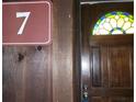View of the home's front door with a stained glass window and a sign with the number 7 at 7 Quail Run, Decatur, GA 30035