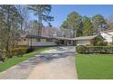 Charming home featuring a brick facade, a spacious driveway, and a two-car garage at 505 River Valley Rd, Sandy Springs, GA 30328