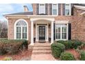 Elegant front entrance with a portico, columns, and a black door at 2678 Bonaire Ter, Marietta, GA 30066