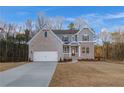 Two-story home with gray siding, brick accents, and a three-car garage at 508 Dolce Rd, Locust Grove, GA 30248