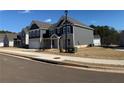 Two-story home with gray siding and brick accents, situated on a corner lot at 203 Arabella Pkwy, Locust Grove, GA 30248