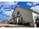 Charming exterior view of the home featuring yellow siding, a well-maintained lawn and a blue sky at 2374 Suwanee Pointe Dr, Lawrenceville, GA 30043