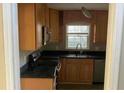 L-shaped kitchen with light wood cabinets and dark countertops at 3428 Vandiver Dr, Marietta, GA 30066