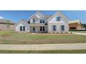 Two story home with light brick and siding, landscaping, and driveway at 443 Lothbury Ave, Locust Grove, GA 30248