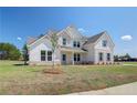 Two story home with light brick and siding, landscaping, and driveway at 443 Lothbury Ave, Locust Grove, GA 30248