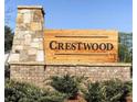 Stone and brick sign for the Crestwood Community with a natural wooden sign and manicured landscaping at 1070 Crest Mill Dr, Marietta, GA 30008