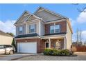 Two-story house with a gray and brick exterior, a two-car garage, and a well-manicured lawn at 100 Canyons Ct, Hampton, GA 30228