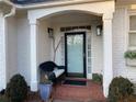 Charming front porch with brick flooring, black wicker chair, and lush greenery at 1814 Tristan Se Dr, Smyrna, GA 30080