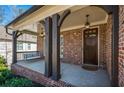 Inviting front porch with brick base, hanging lanterns, and a cozy swing at 337 Ellis Preserve Sw Ln, Marietta, GA 30064