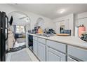 Kitchen features white cabinets and a view of the living room at 6715 Biscayne Blvd, Rex, GA 30273