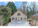 Charming home showcasing a well-manicured front yard, concrete driveway, and inviting entryway, surrounded by mature trees at 2843 Merritt Dr, Buford, GA 30518