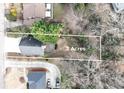 Aerial view of a property highlighting its .2 acre lot size with mature trees and convenient circular driveway at 2843 Merritt Dr, Buford, GA 30518