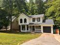 Charming two-story home with a manicured lawn, black windows, black door and an attached garage at 1126 Williamsburg Ln, Norcross, GA 30093