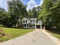 Charming two-story home with a manicured lawn, black windows, black door and an attached garage at 1126 Williamsburg Ln, Norcross, GA 30093