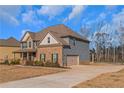 Side view of a two-story home showcasing the attached garage and driveway at 149 Elkins Blvd, Locust Grove, GA 30248