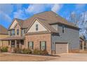 Another side view of the two-story home highlighting the garage and landscaping at 149 Elkins Blvd, Locust Grove, GA 30248