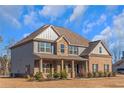 Shows the front view of the two-story home with landscaping and a nice lawn at 149 Elkins Blvd, Locust Grove, GA 30248