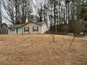 This single-story home features neutral siding, a well-maintained lawn and a vibrant blue front door at 22 Cardinal Ln, Jonesboro, GA 30238