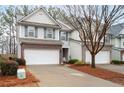 Two-story townhome with brick and siding exterior, two-car garage, and landscaping at 439 Mountain View Ln, Woodstock, GA 30188