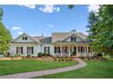 Inviting home featuring a brick walkway, manicured lawn, a covered porch, and lush landscaping at 101 Barker Rd, Cumming, GA 30040