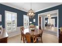 Formal dining room with a dark wood table, chandelier, and hardwood floors at 100 Kendemere Pointe, Roswell, GA 30075