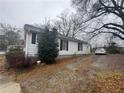 Side view of a one-story home with a gravel driveway and some shrubbery at 3453 Woodlawn Cir, Tucker, GA 30084