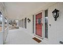 Front porch with white columns, red door, and a white floor at 5422 Hill Sw Rd, Powder Springs, GA 30127