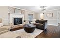 Comfortable living room features a brick fireplace, neutral decor, and hardwood floors at 5422 Hill Sw Rd, Powder Springs, GA 30127