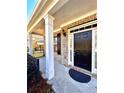 Front entrance with a covered porch, columns, and a black door at 3026 Bridge Walk Dr, Lawrenceville, GA 30044