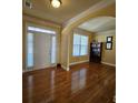 Inviting living room with hardwood floors, crown molding, large windows, and an arched doorway at 3026 Bridge Walk Dr, Lawrenceville, GA 30044