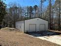 White metal garage with two roll-up doors at 5670 Lanny Dr, Powder Springs, GA 30127