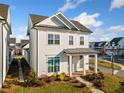 Beautiful two-story white home featuring a covered entryway, lush lawn, and professional landscaping in a desirable neighborhood at 1026 Cagle Creek Overlook, Canton, GA 30115