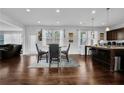 Open concept dining area featuring hardwood floors, modern lighting, and seating for four at 1202 Ida Woods Ln, Lawrenceville, GA 30045