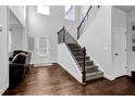 Bright foyer with hardwood floors, staircase with dark wood and iron railing, and a view into the living room at 1202 Ida Woods Ln, Lawrenceville, GA 30045