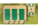 Three tennis courts and a basketball court with green surfaces at 13218 E Tolstoy Se Drs, Covington, GA 30014