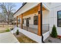 Inviting front porch featuring exposed wood beams, black railings, and a stained wood ceiling at 467 Concord Sw Rd, Smyrna, GA 30082