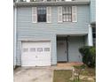 Light blue two-story townhouse with white garage door and shutters at 1604 Pine Tree Trl, Atlanta, GA 30349