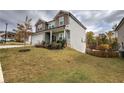 Exterior view of a two-story home with a well-maintained lawn, landscaping and a welcoming front porch at 419 Murphy Ave, Canton, GA 30114