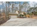 Tan house with a two-car garage and wooden stairs leading to the entrance at 680 Branch Valley Ct, Roswell, GA 30076