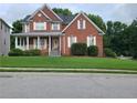 Two-story brick home with a covered porch and manicured lawn at 100 Meadow Lake Dr, Carrollton, GA 30116
