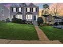 Updated two-story townhome with a manicured lawn at dusk at 1042 Plantation Nw Way, Kennesaw, GA 30144