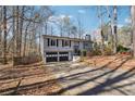 Split-level home features two-car garage and driveway leading up to the home with mature trees at 190 Hembree Forest Cir, Roswell, GA 30076