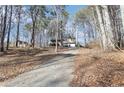 House nestled among trees with a long driveway leading to the entrance at 65 Bridge Dr, Douglasville, GA 30134