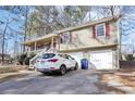 Tan house with red shutters and a white double garage door. A white SUV is parked in the driveway at 65 Bridge Dr, Douglasville, GA 30134