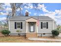 Inviting front porch with American flag of a charming single-story home with gray siding and black shutters at 189 Parkview Se Dr, Marietta, GA 30060