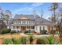 Beautiful two-story home featuring stone accents, a covered front porch, and a well-manicured lawn with mature trees at 2290 Spencers Way, Stone Mountain, GA 30087